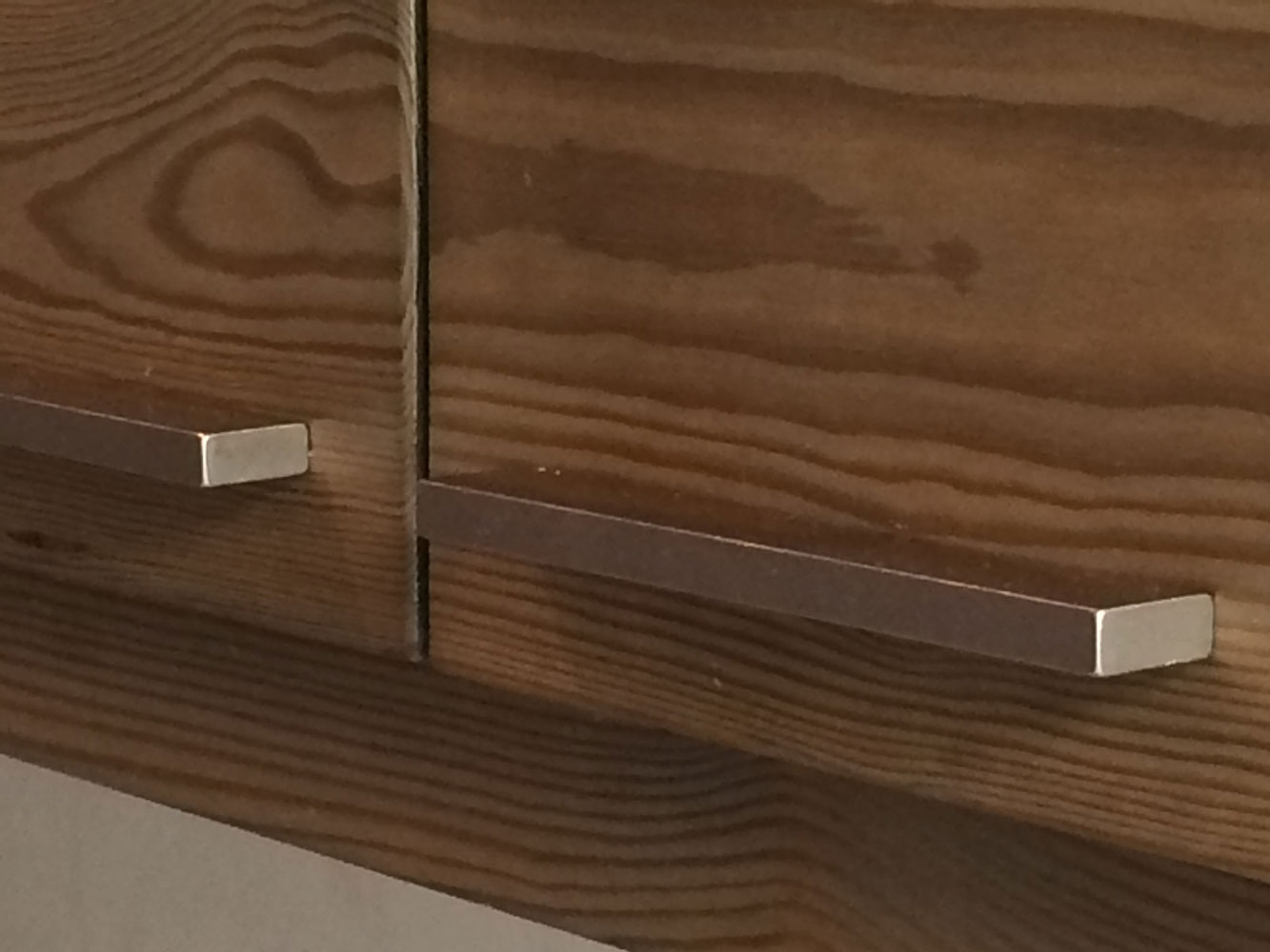 brushed steel handles on aged wood kitchen