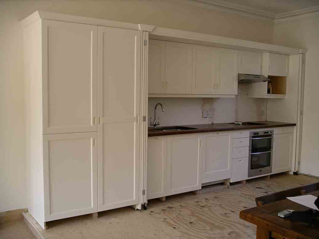 hide-away bespoke kitchen with dark oak worktop